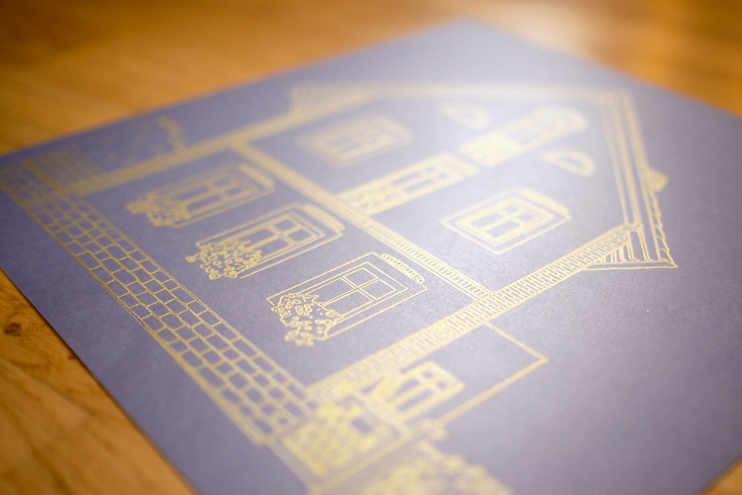 Haus als handgezeichnete Goldlinien-Zeichnung auf blauem Papier vom Schreibroboter – detailreiche Architektur-Illustration